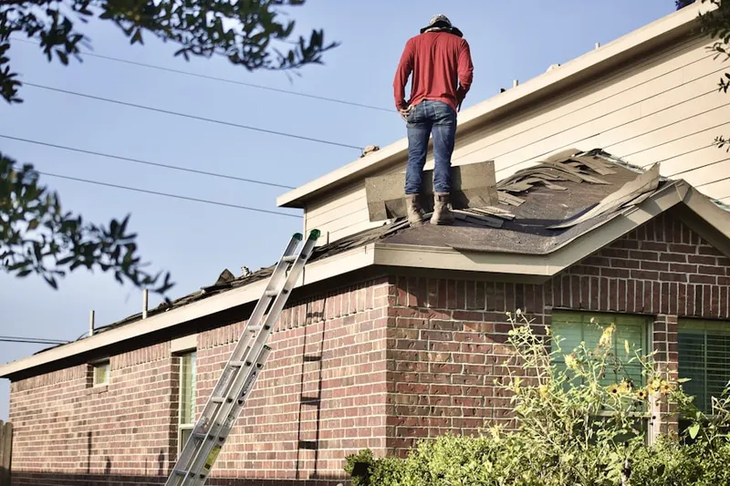 Professional roofer working on a residential roof in West Frankfort